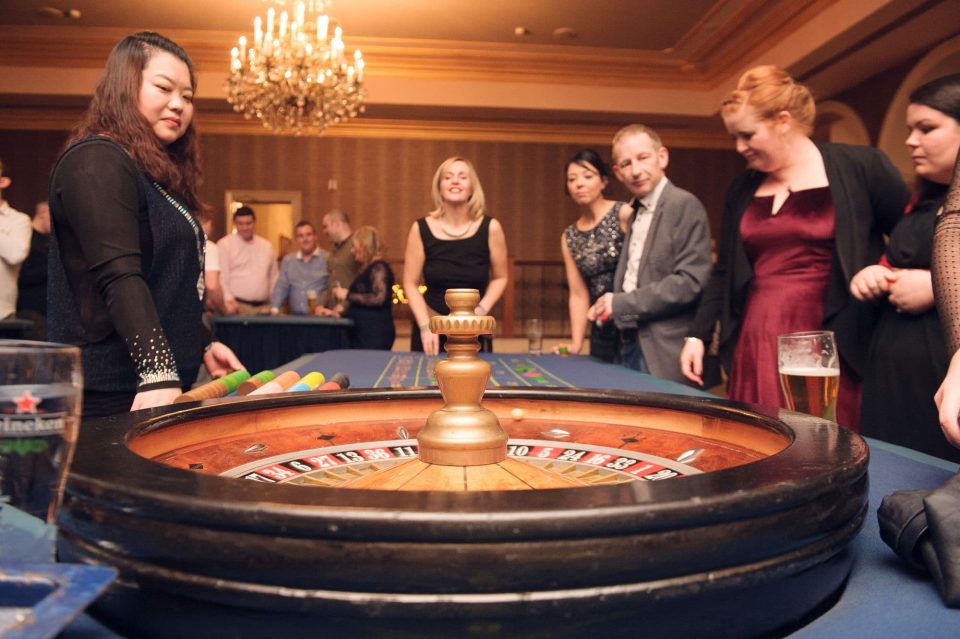 a group of employees are enjoying the roulette table at a Vegas night themed corporate event in Dublin