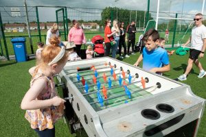Kids are playing foosball at a family fun day summer party event in Cork